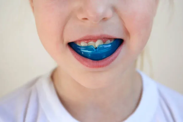 Dental simulator for teeth alignment . The child has mouth guards on his teeth.